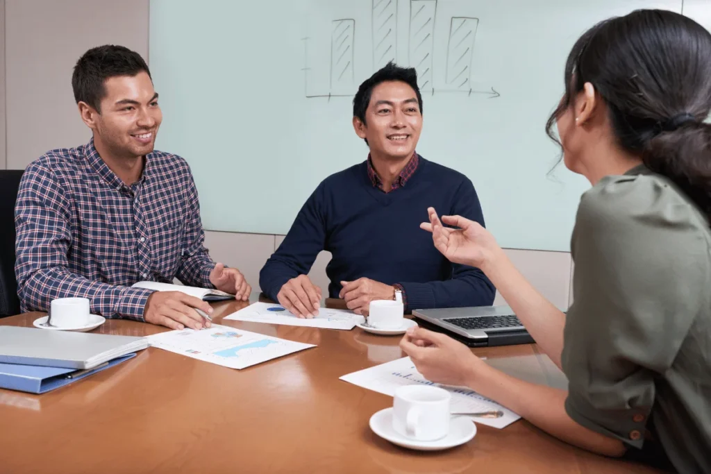 Group of professionals discussing reports at a meeting table.