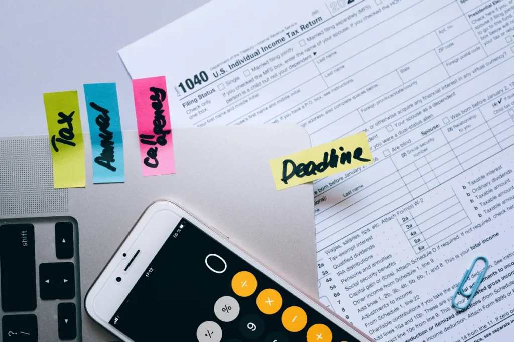 U.S. tax form 1040 with calculator and sticky notes on deadlines.