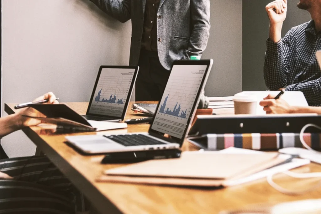 Closeup of laptops showing bar chart reports during business presentation.