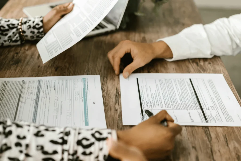 Close-up of hands analyzing tax forms and financial paperwork.