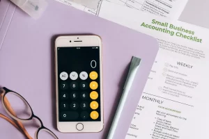 Small business accounting checklist with smartphone calculator.