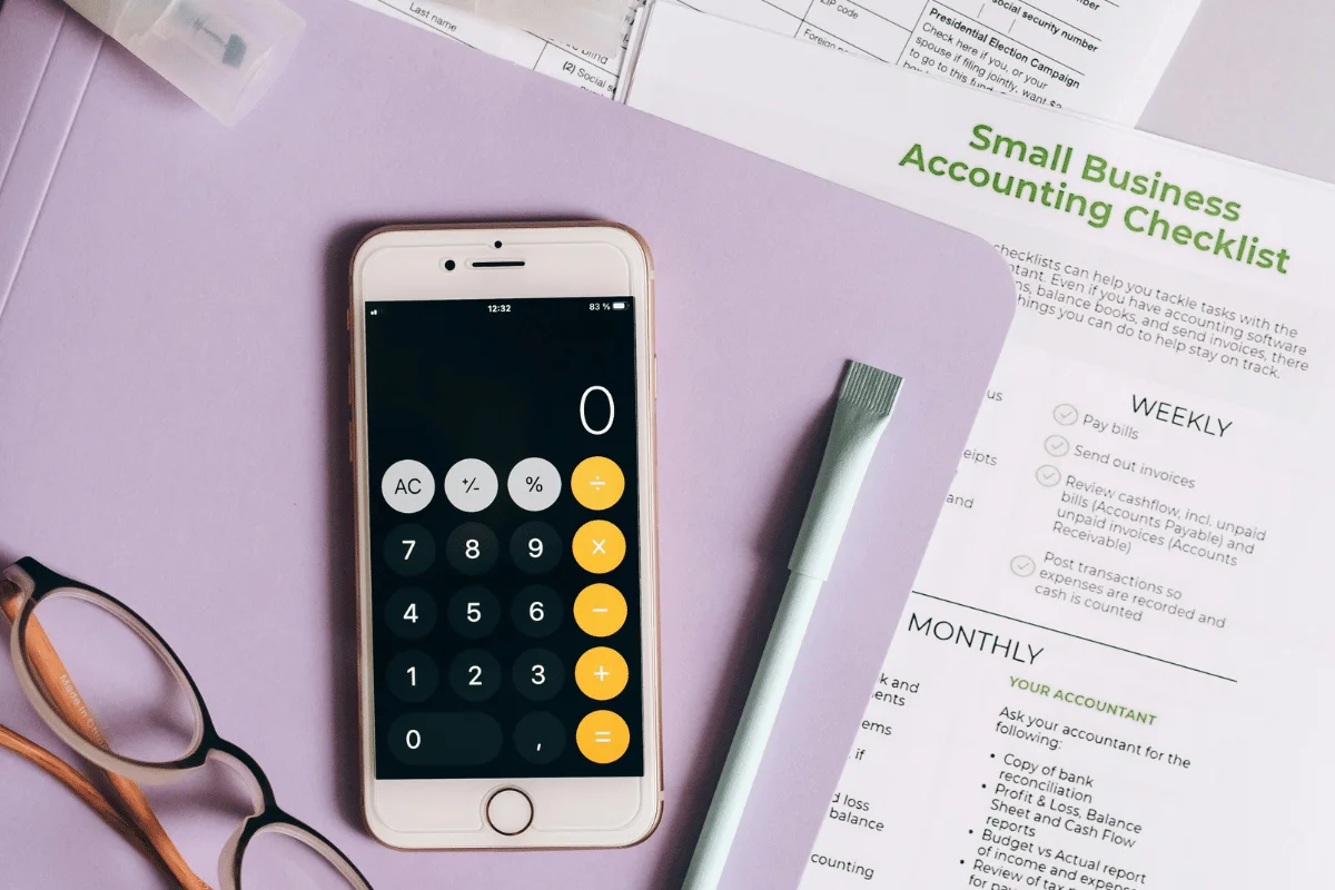 Small business accounting checklist with smartphone calculator.