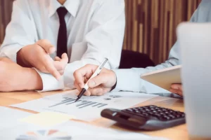 Three people in business attire are engaged in a meeting.