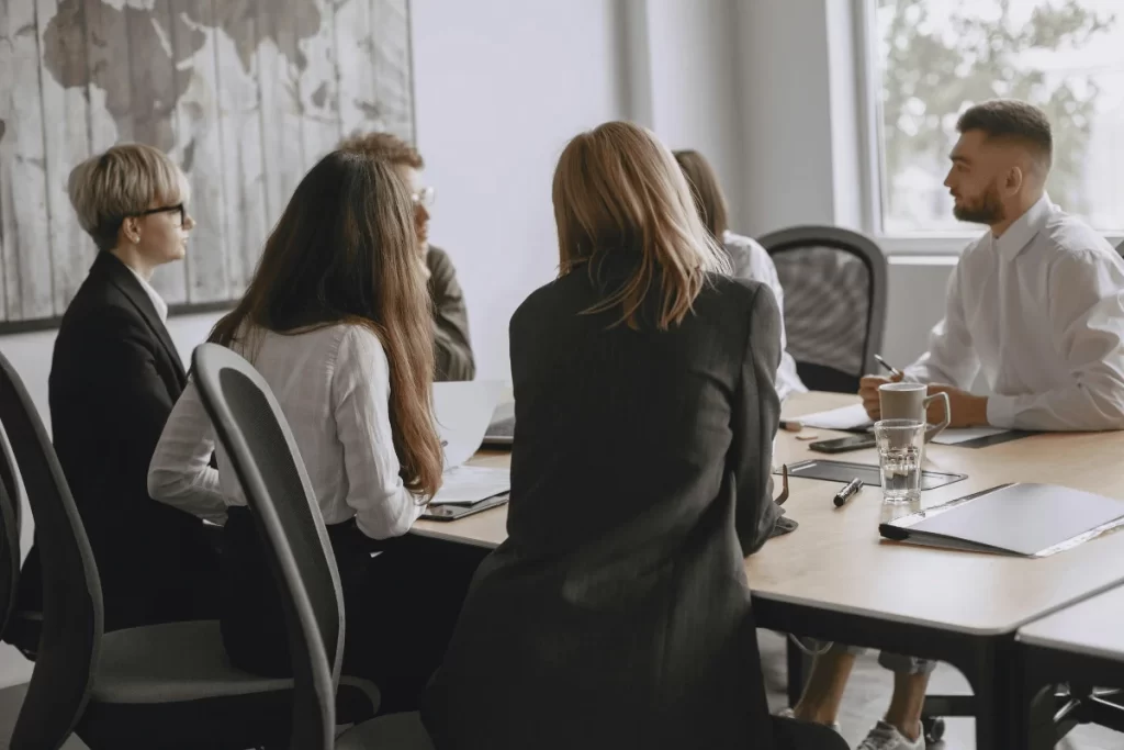 Business team meeting around a conference table in an office.