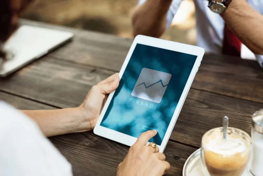 Tablet screen displaying finance analytics with rising chart in outdoor setting.