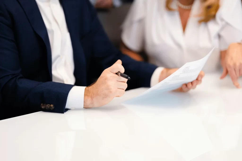 Professional team analyzing and signing documents in a corporate setting.