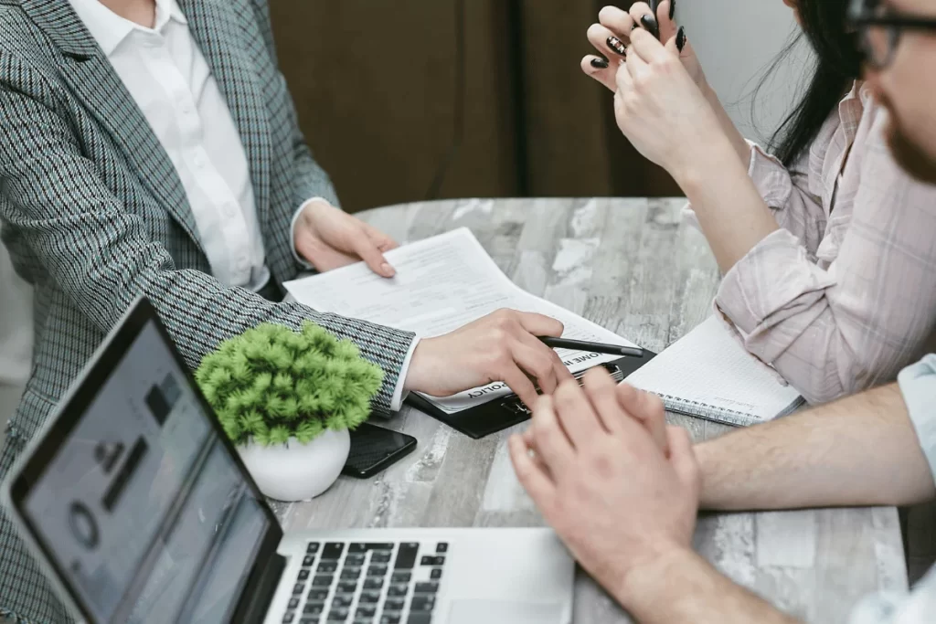 Team collaborating around a table reviewing business documents.