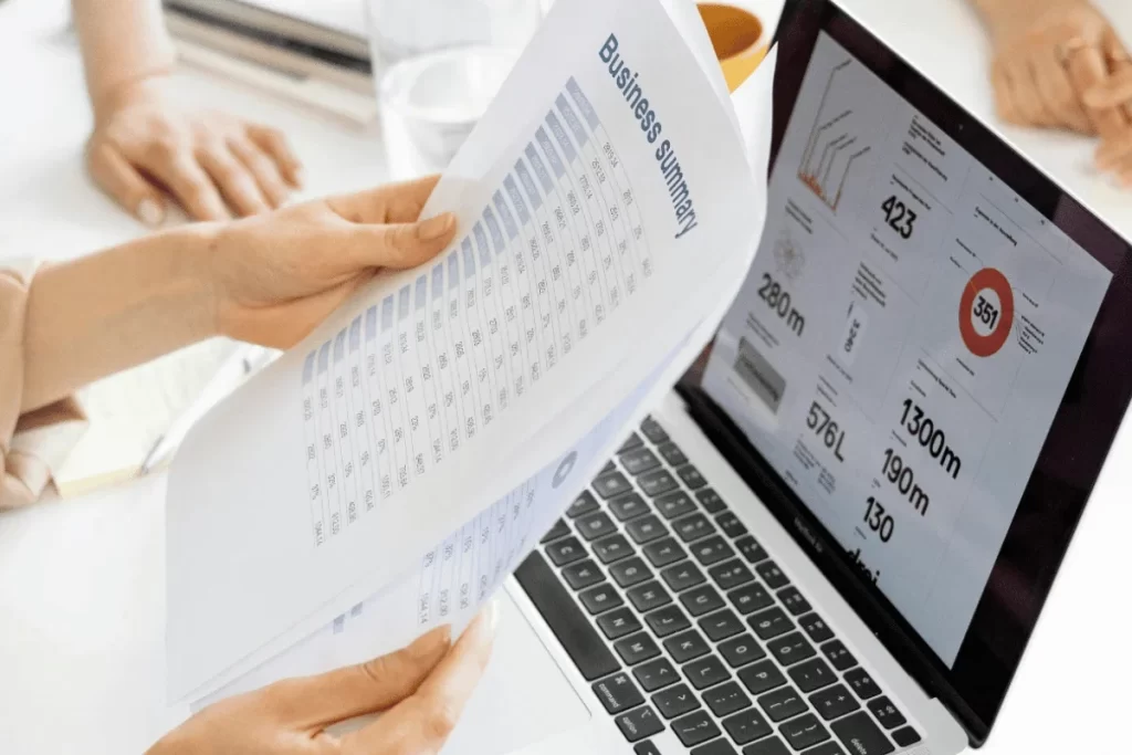Business report with charts and numbers being compared to digital graphs.