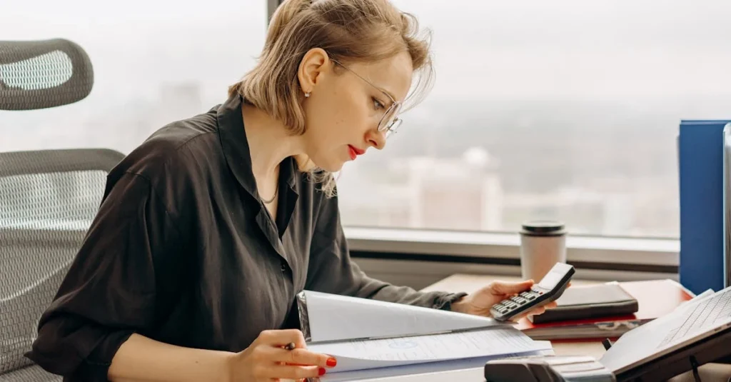 Person calculating business expenses with calculator, notepad, cash and receipts while buying business Ontario.