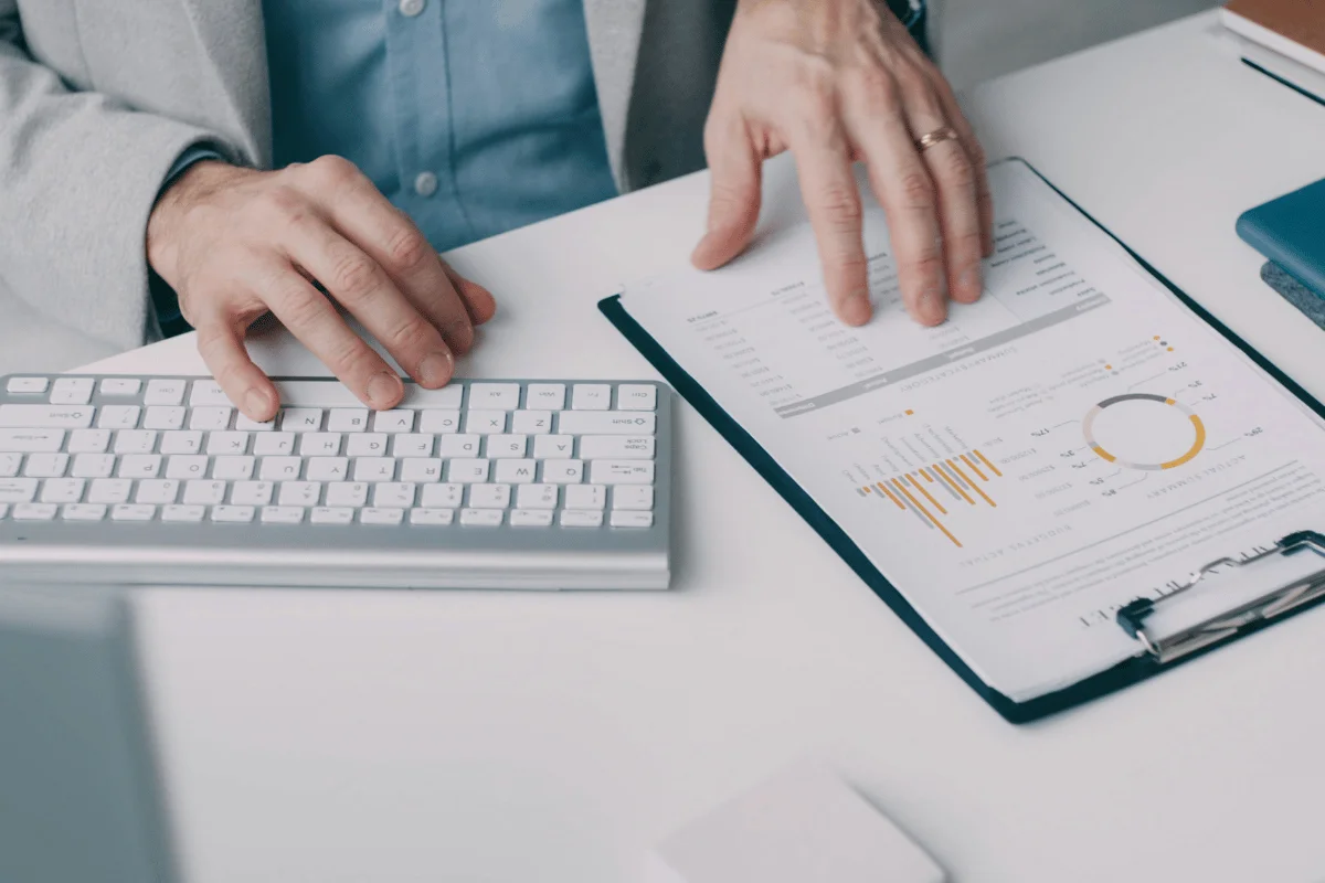 Professional reviewing data charts while working on computer.