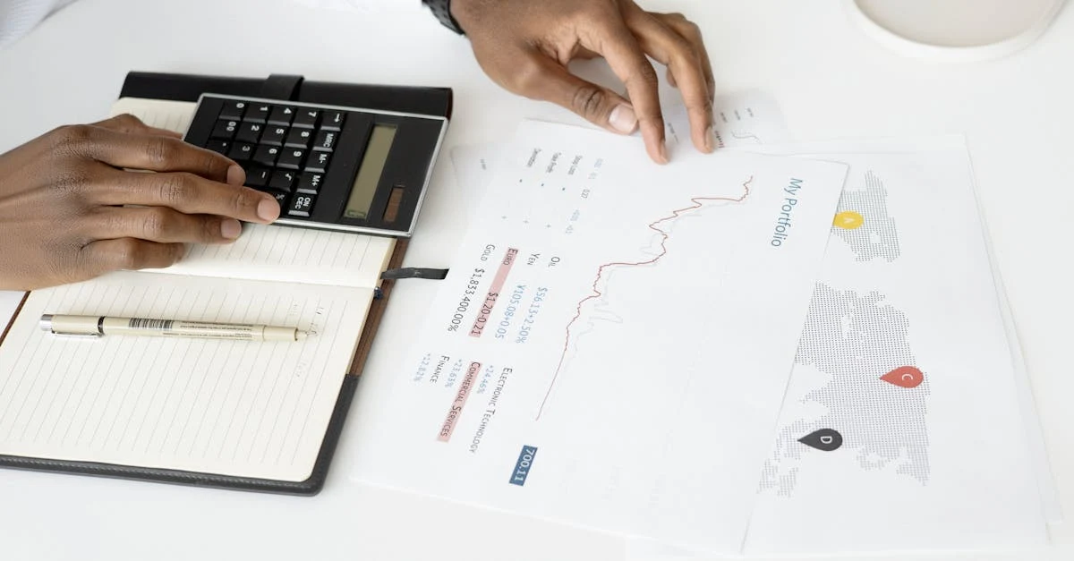 Person using calculator and analyzing software industry integration savings charts on desk.