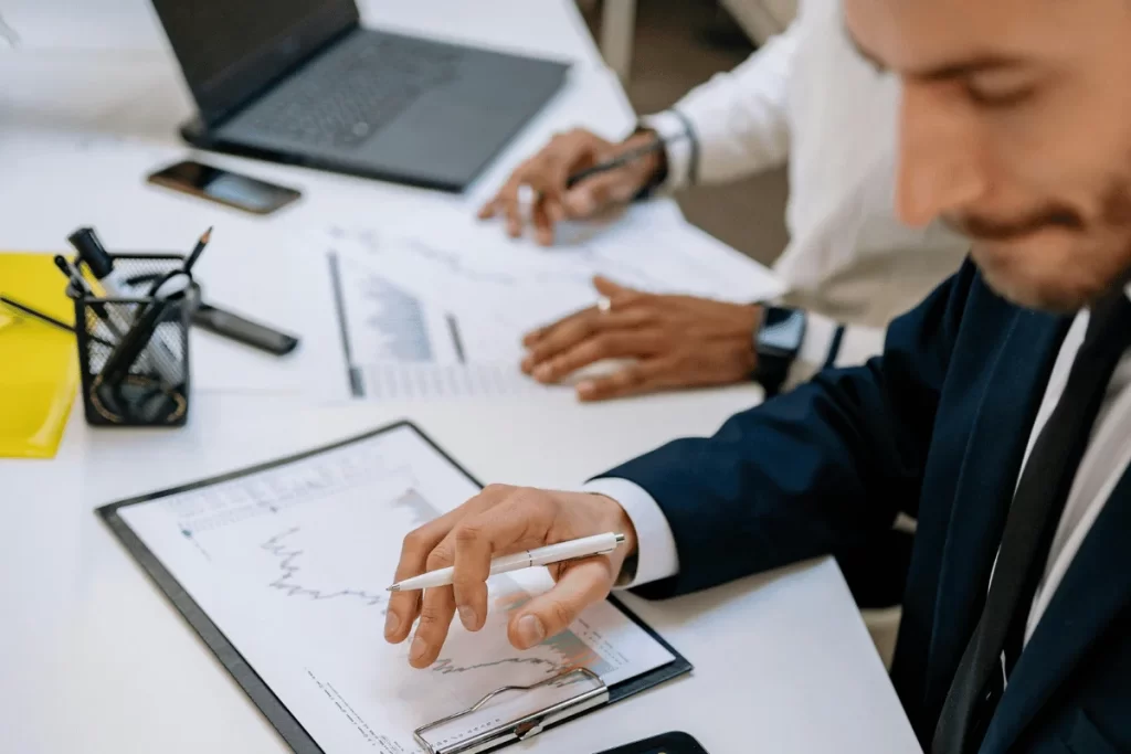 Close-up of hands analyzing financial data and reports.