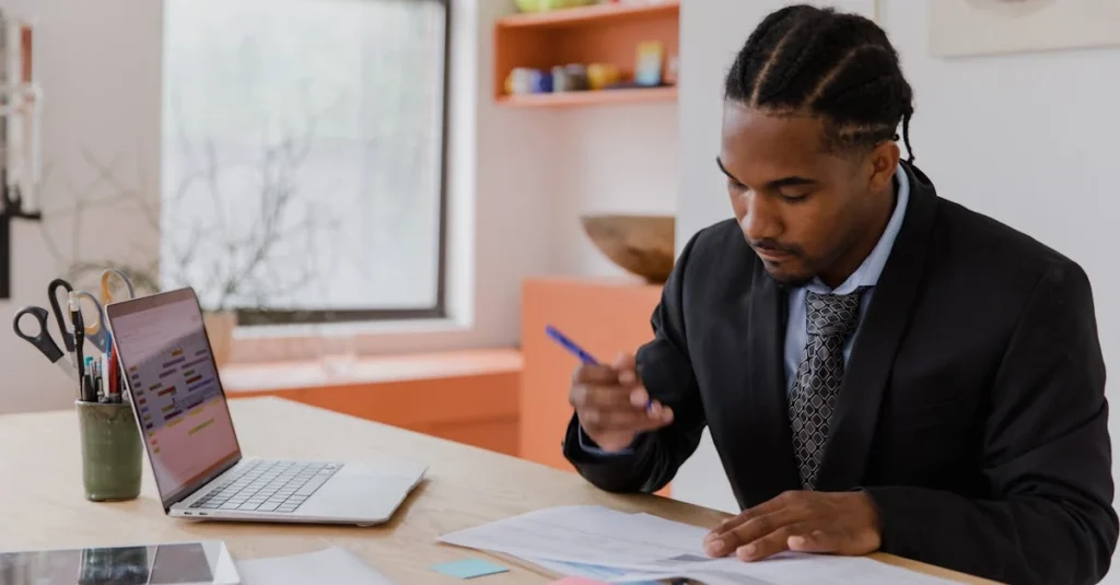 Person filling out tax form with cash and laptop, researching buying business Ontario regulations and financial documents.