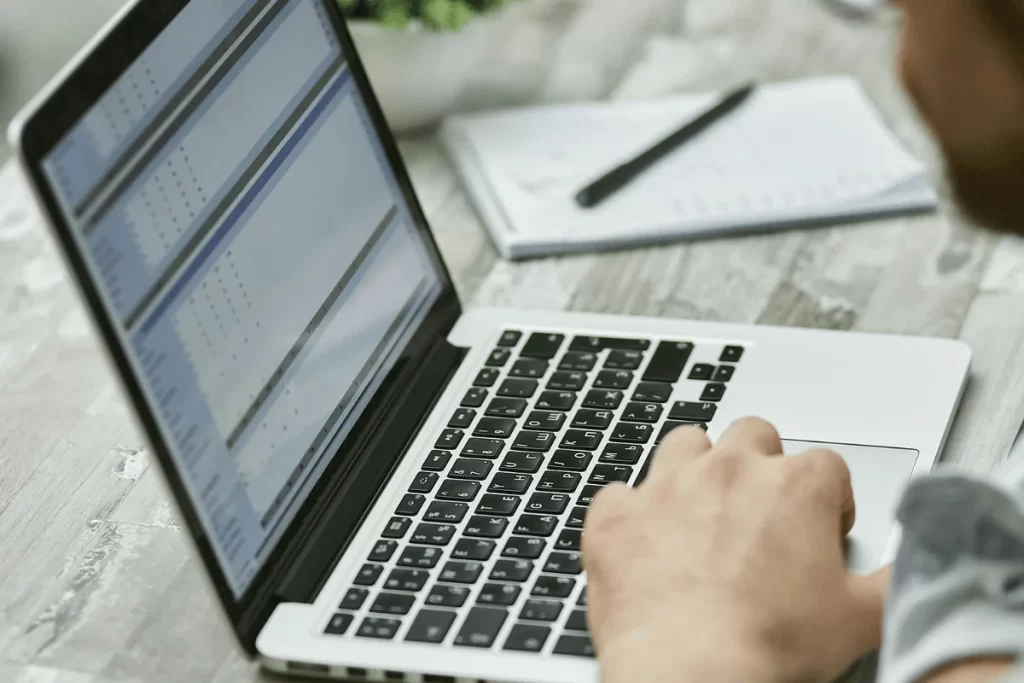 Close-up of accountant analyzing data in Excel on laptop.