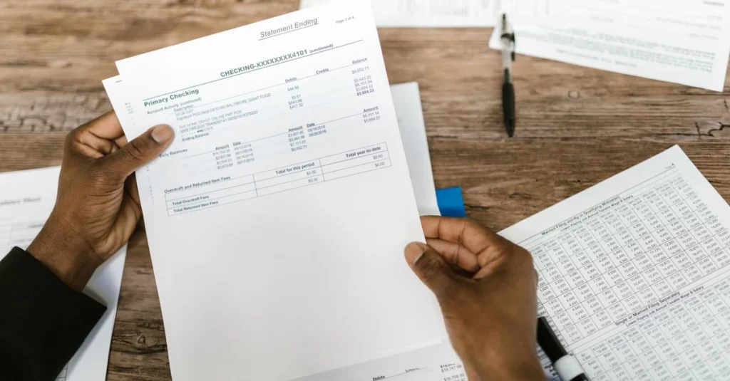 Hands holding financial documents and spreadsheets while evaluating business buying toronto opportunity.