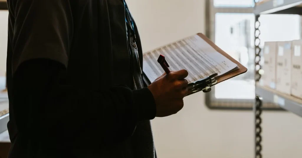 Person holding clipboard with checklist while buying existing business in retail store environment.
