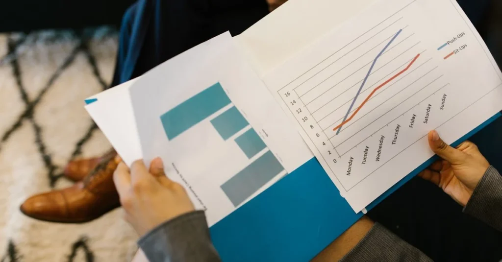 Professional reviewing SaaS valuation calculator results with charts and growth trend graphs on printed reports.